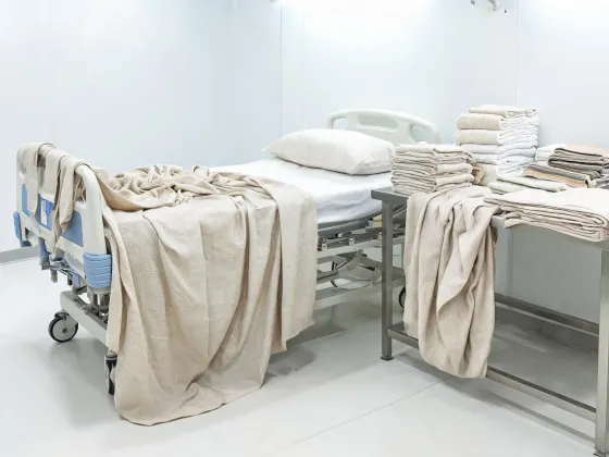 Woven bed and bath linen fabric beside institutional bed components